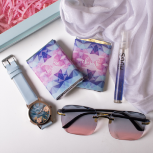 an image of a gift box with chocolate perfume, watch and a sunglass for a girl